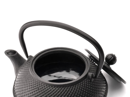 Black textured cast iron teapot on a white background
