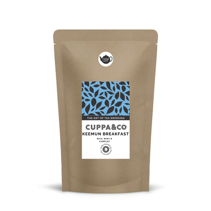 Packaged pouch of tea named 'Keemun Breakfast' by brand Cuppa & Co with label in blue, black and white displaying product information and leaf patterns also a separate round label with black teapot and wording 'LOOSE LEAF'