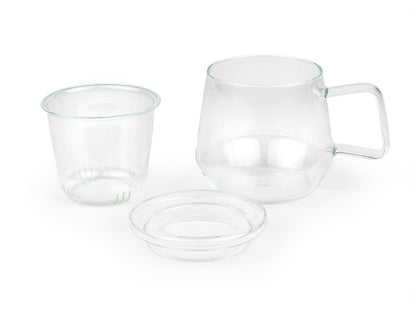 3 piece clear glass mug with handle sitting next to its removed glass infuser and lid on a white background