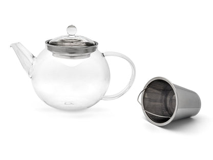 Curved clear glass teapot next to the removable stainless steel  filter on a white background
