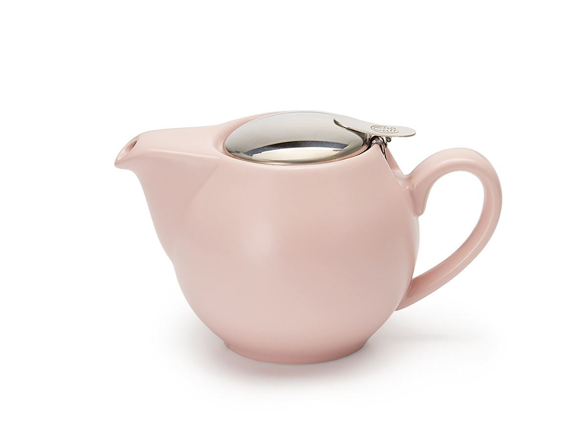 Pale pink porcelain teapot with a fixed silver lid on a white background