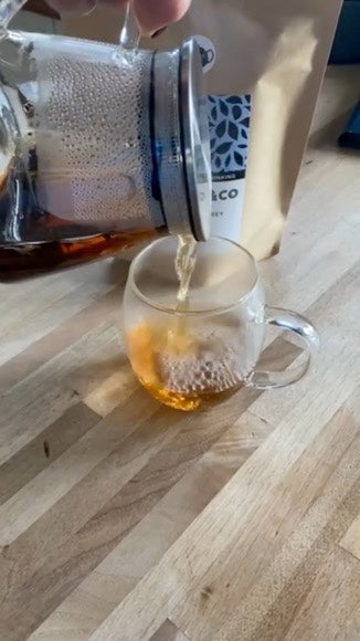 video of 532ml glass teapot with tea leaf filter in lid pouring brewed loose leaf tea into a glass cup.