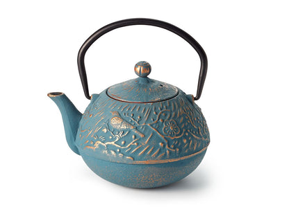 Blue and gold cast iron teapot with decorative relief pattern on a white background