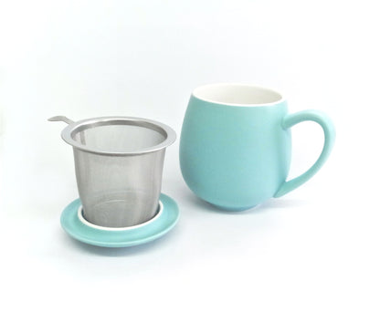 Teal porcelain tea mug with metal tea infuser sitting on a lid on a white background