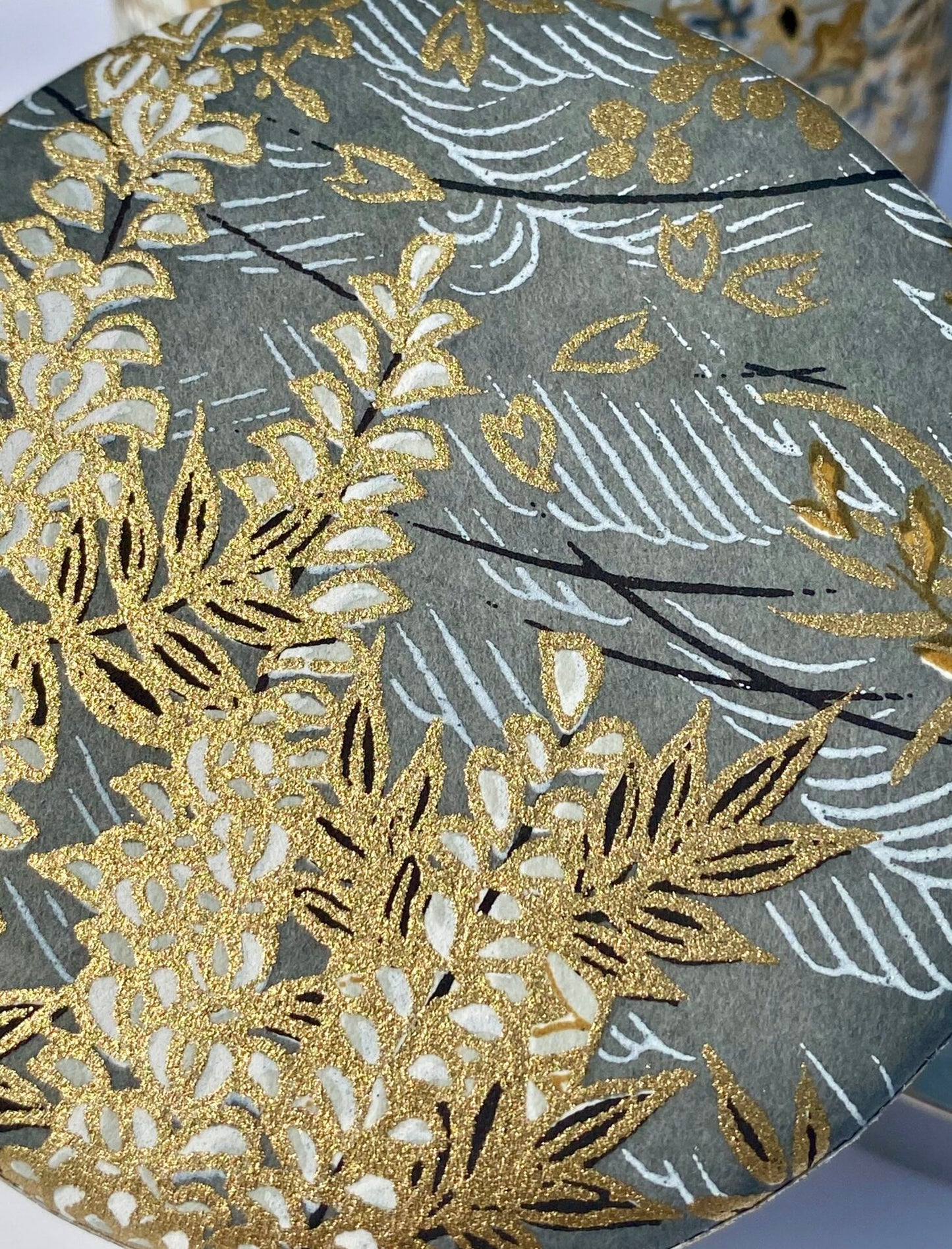 Decorative paper with gold and white floral patterns on a grey background