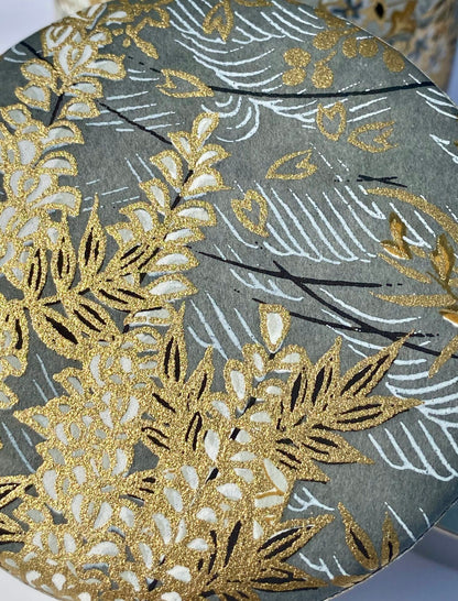 Decorative paper with gold and white floral patterns on a grey background